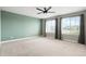 A bright bedroom with natural light from two windows with drapes, and carpeted floors at 26322 E 2Nd Ave, Aurora, CO 80018