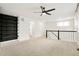 A bonus room with carpeted floors, a ceiling fan, a dark built-in bookshelf, and a railing at 26322 E 2Nd Ave, Aurora, CO 80018