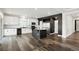 Kitchen featuring white cabinets, a dark island, stainless steel appliances, and hardwood floors at 26322 E 2Nd Ave, Aurora, CO 80018