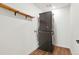 A laundry room showcasing a stacked washer and dryer unit and a wooden shelf with metal brackets at 26322 E 2Nd Ave, Aurora, CO 80018