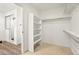 Walk-in closet with built-in shelving, carpeted floors, and an entrance to the bathroom at 26322 E 2Nd Ave, Aurora, CO 80018