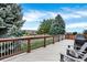 Spacious wooden deck with white railings, outdoor seating, grill, and a view of lush landscaping at 11575 Wilson Cir, Parker, CO 80134