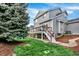 Exterior of the house with a spacious deck, lush green lawn, and mature trees at 11575 Wilson Cir, Parker, CO 80134