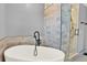 Bathroom featuring a luxurious tub and glass shower enclosure with neutral tiling at 11575 Wilson Cir, Parker, CO 80134