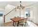 A bright dining room boasts a modern chandelier, wood dining table, and staircase at 11575 Wilson Cir, Parker, CO 80134