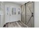 Inviting foyer with stylish wood-look flooring, decorative glass door and modern sliding barn doors at 7420 Windwood Way, Parker, CO 80134