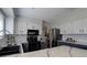 Contemporary kitchen features stainless steel appliances, white upper cabinets and dark lower cabinets at 7420 Windwood Way, Parker, CO 80134