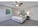 Comfortable bedroom features a ceiling fan, neutral carpet, and picture window at 7420 Windwood Way, Parker, CO 80134