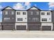 Modern townhome exterior with garage doors and mixed siding at 6824 Huddersfield Ln, Castle Pines, CO 80108