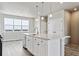 Modern kitchen features a large window, bright white cabinets, and a kitchen island with pendant lighting at 6824 Huddersfield Ln, Castle Pines, CO 80108