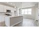 Bright modern kitchen with white cabinetry, a central island, and an adjacent dining area at 6824 Huddersfield Ln, Castle Pines, CO 80108