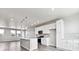 Modern kitchen featuring white cabinets, an island with bar seating, and wood-look flooring at 6824 Huddersfield Ln, Castle Pines, CO 80108