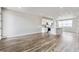 Spacious living room next to a modern kitchen with stainless appliances and hardwood style flooring at 6824 Huddersfield Ln, Castle Pines, CO 80108