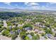 An aerial view displays the home and its neighborhood with views of the mountains in the distance at 9015 W Tanforan Dr, Littleton, CO 80123