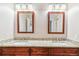 Bathroom features dual sinks, granite countertops, wood cabinets, and tiled shower/tub combo at 9015 W Tanforan Dr, Littleton, CO 80123