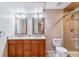 Bathroom with dual vanities, granite countertops, and a glass-enclosed tile shower create a luxurious retreat at 9015 W Tanforan Dr, Littleton, CO 80123