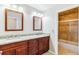 Bathroom showcases dual sinks, granite countertops, wood cabinets and a tiled shower/tub combo at 9015 W Tanforan Dr, Littleton, CO 80123
