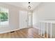 Bright entryway with wood flooring features a contemporary light fixture and staircase leading to a second floor at 9015 W Tanforan Dr, Littleton, CO 80123