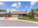Attractive single-story home with a two-car garage, green lawn, and a classic brick accent at 9015 W Tanforan Dr, Littleton, CO 80123