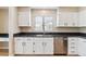 Well-appointed kitchen boasts white cabinets, stainless steel appliances, and granite countertops at 9015 W Tanforan Dr, Littleton, CO 80123