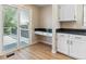 Bright kitchen nook with slider to the deck, built in desk, and white cabinets at 9015 W Tanforan Dr, Littleton, CO 80123