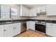 Kitchen featuring white cabinets, granite countertops, stainless steel appliances, and wood-look flooring at 9015 W Tanforan Dr, Littleton, CO 80123