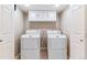 Bright laundry room boasts ample storage cabinets above side-by-side washer and dryer at 9015 W Tanforan Dr, Littleton, CO 80123