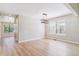 Bright living room with wood flooring features a modern light fixture, large window, and neutral walls at 9015 W Tanforan Dr, Littleton, CO 80123