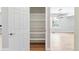 Bright pantry features white shelving and opens to a living area with wood floors and neutral paint at 9015 W Tanforan Dr, Littleton, CO 80123