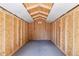 Spacious shed with wooden beams and a concrete floor, is perfect for storage or workshop at 9015 W Tanforan Dr, Littleton, CO 80123