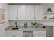 Basement kitchen features white cabinets and a sleek sink at 5965 W Quarles Dr, Littleton, CO 80128