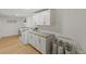 Laundry room with white cabinets and light wood floors at 5965 W Quarles Dr, Littleton, CO 80128