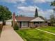 Charming brick ranch home with a well-manicured lawn and mature landscaping at 9115 W 5Th Ave, Lakewood, CO 80226