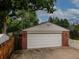Detached two-car garage with brick accents and a white picket fence at 9115 W 5Th Ave, Lakewood, CO 80226