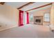 Bright living room with wood beam ceiling, gas fireplace, neutral carpet, and large window at 9115 W 5Th Ave, Lakewood, CO 80226