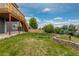 Expansive backyard featuring lush green grass and a multi-tiered retaining wall with landscaping for outdoor enjoyment at 2509 S Bahama Way, Aurora, CO 80013