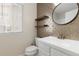 Modern half-bath featuring unique gold tile wall and floating shelves at 2509 S Bahama Way, Aurora, CO 80013