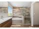 Modern bathroom featuring wood-style tile, glass shower, separate tub, and bright natural light from the window at 2509 S Bahama Way, Aurora, CO 80013