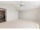 Spacious and neutral bedroom featuring a vaulted ceiling, fan, and access to the bathroom at 2509 S Bahama Way, Aurora, CO 80013