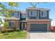 Charming two-story home featuring a brick facade, gray siding, and attached two-car garage, plus a well-manicured lawn at 2509 S Bahama Way, Aurora, CO 80013