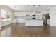 Spacious kitchen with white cabinets, stainless steel appliances, hardwood floors, and an island with bar seating at 2509 S Bahama Way, Aurora, CO 80013