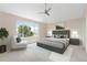 Stylishly staged main bedroom with a vaulted ceiling, ceiling fan, accent wall, and large window at 2509 S Bahama Way, Aurora, CO 80013