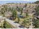 Aerial view of a blue ranch home with surrounding wooded area and road access at 5384 Olde Stage Rd, Boulder, CO 80302