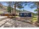 Exterior view of a blue home with stone accents and a detached garage, set amidst trees and landscaping at 5384 Olde Stage Rd, Boulder, CO 80302