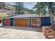 Detached garage with a large wooden door, stylish entry door and concrete driveway at 5384 Olde Stage Rd, Boulder, CO 80302