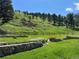 Landscaped yard with a charming stone retaining wall and wooden fence, offering privacy and natural beauty at 5384 Olde Stage Rd, Boulder, CO 80302