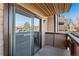 Enclosed balcony with sliding glass doors and wood railing, offering a private outdoor space with overhead covering at 7040 W 20Th Ave # 206, Lakewood, CO 80214