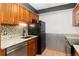 This kitchen features wooden cabinets, granite countertops, and stainless-steel dishwasher at 7040 W 20Th Ave # 206, Lakewood, CO 80214