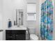Clean bathroom with modern vanity, toilet, and a colorful shower curtain, creating a refreshing space at 15802 Xanthia Way, Thornton, CO 80602