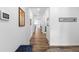 Spacious hallway with wood floors, leading to various rooms, and featuring wall decorations and light fixtures at 15802 Xanthia Way, Thornton, CO 80602
